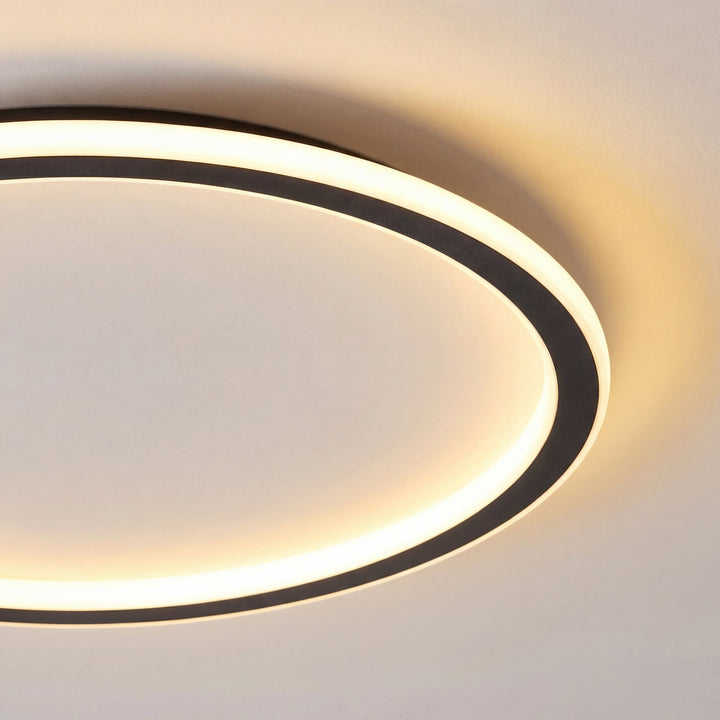 Close-up van een deel van de zwarte ring met het gloeiende lichtbandje, waarop de dunne, vlakke afwerking goed te zien is. 2