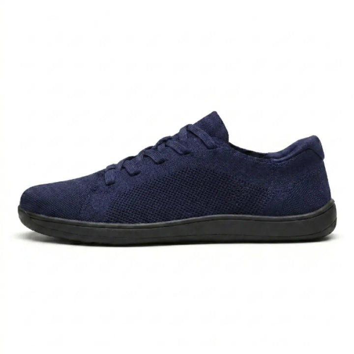 Marineblauwe mesh sneaker van opzij op een witte achtergrond, met blauwe veters en een zwarte zool. 19