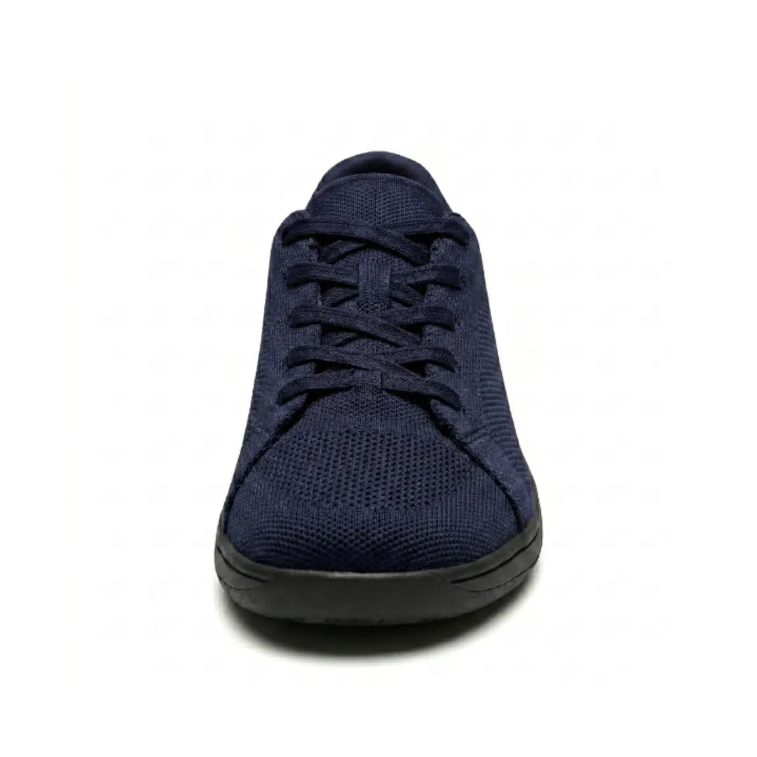 Marineblauwe gebreide sneaker met zwarte zool en veters, recht van voren gezien, met de brede ronde neus. 26