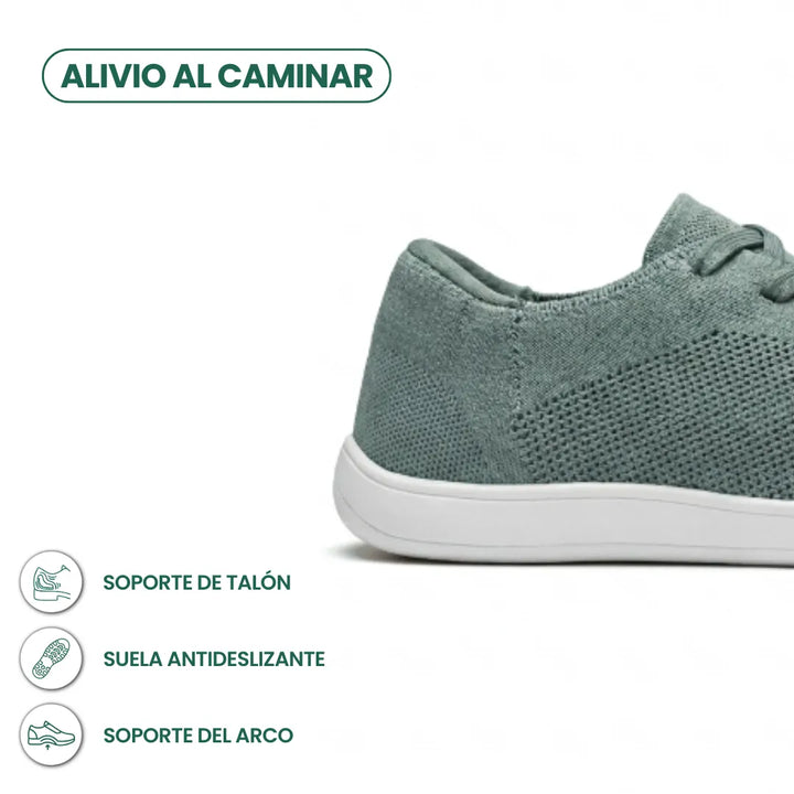 Close-up van de hiel van de saliegroene sneaker met witte zool, met pictogrammen voor hielondersteuning, antislipzool en booggewelfsteun. 31