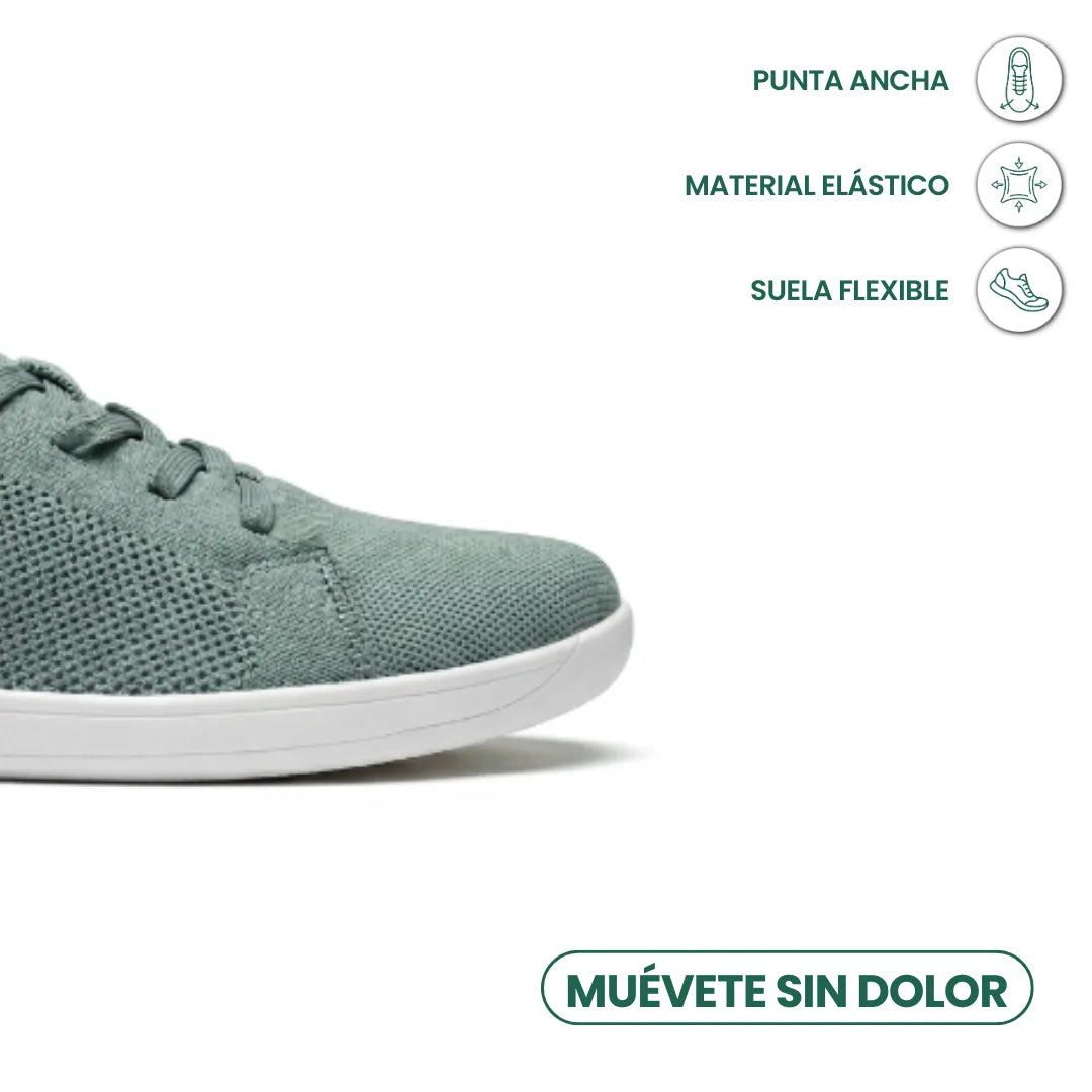 Close-up van de brede neus van de saliegroene sneaker met witte zool, met pictogrammen voor flexibele zool en elastisch materiaal. 32