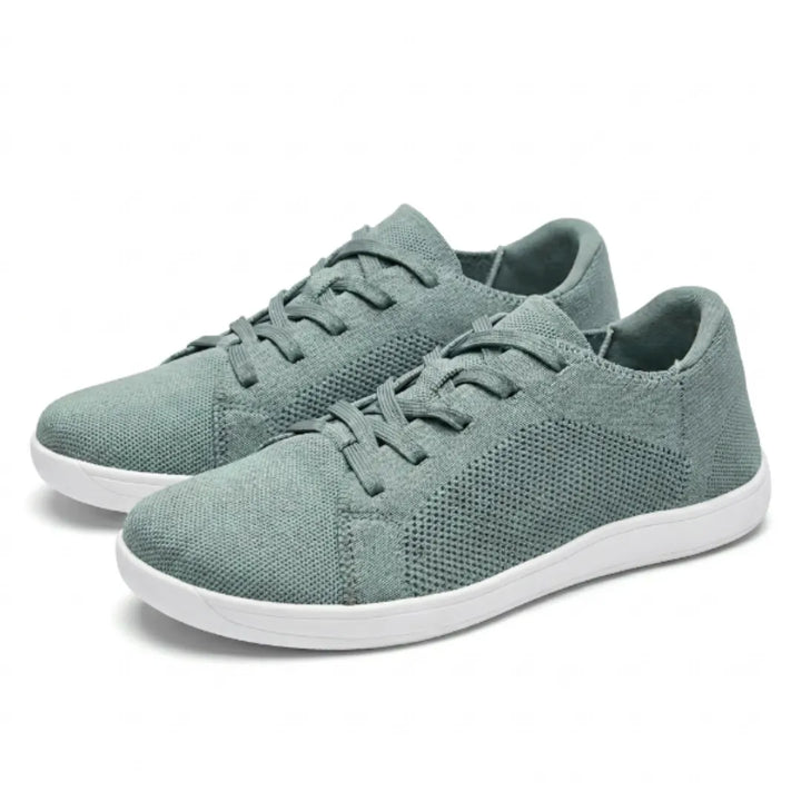 Paar saliegroene gebreide sneakers met witte zool en veters, schuin van opzij gefotografeerd op een witte achtergrond. 34