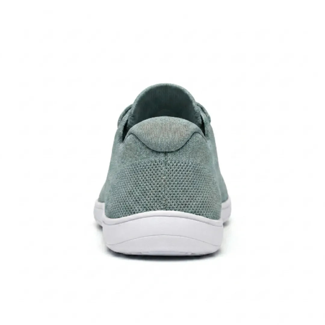 Saliegroene gebreide sneaker met witte zool, van achteren gezien met de gevoerde hielkap en het mesh op de hiel. 36