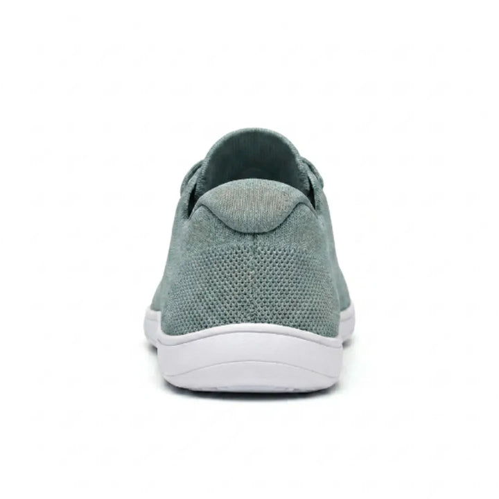 Saliegroene gebreide sneaker met witte zool, van achteren gezien met de gevoerde hielkap en het mesh op de hiel. 36