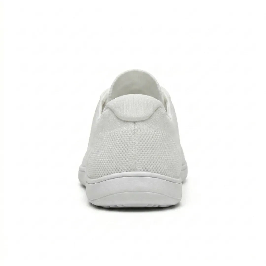 Achterkant van een witte gebreide sneaker met hielstuk van mesh en dunne witte zool op een witte achtergrond. 45
