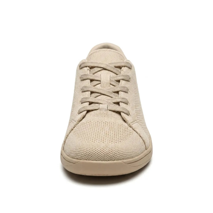 Voorkant van de beige sneaker met de gekruiste veters en het geperforeerde mesh bij de brede neus. 8