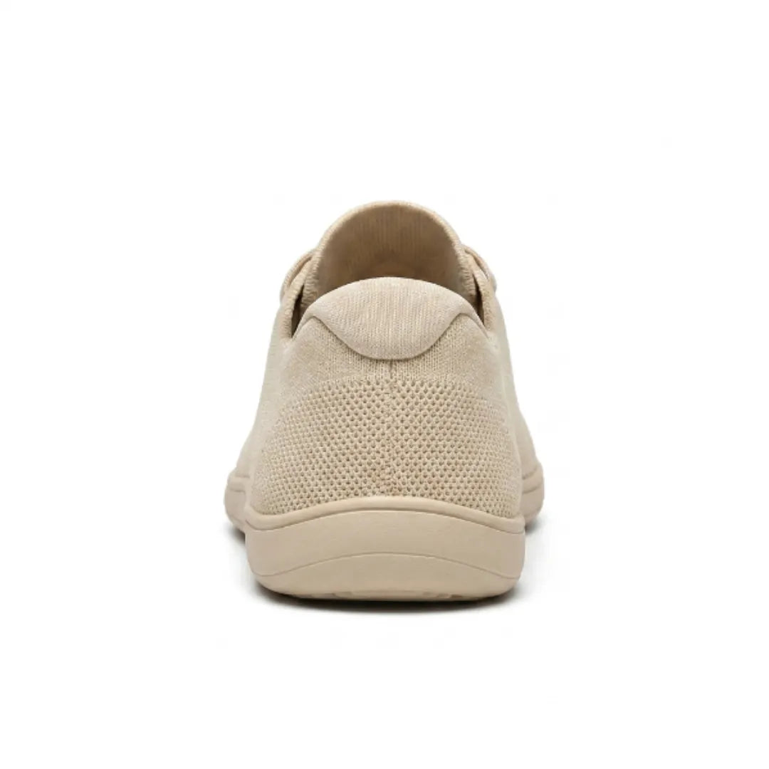 Achterkant van de beige sneaker met de gevoerde hielkap, mesh bovenwerk en de platte beige zool. 9