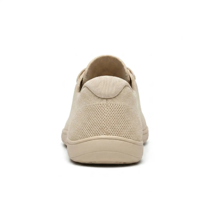 Achterkant van de beige sneaker met de gevoerde hielkap, mesh bovenwerk en de platte beige zool. 9