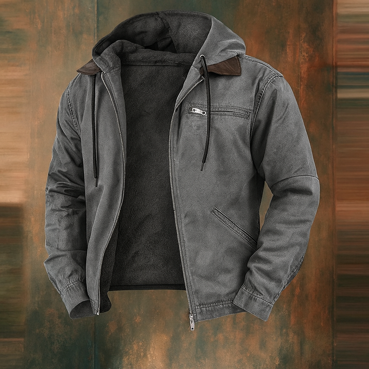 Open grijze jas met capuchon, zwarte trekkoorden en donkere fleecevoering, getoond voor een roestkleurige abstracte achtergrond. 3