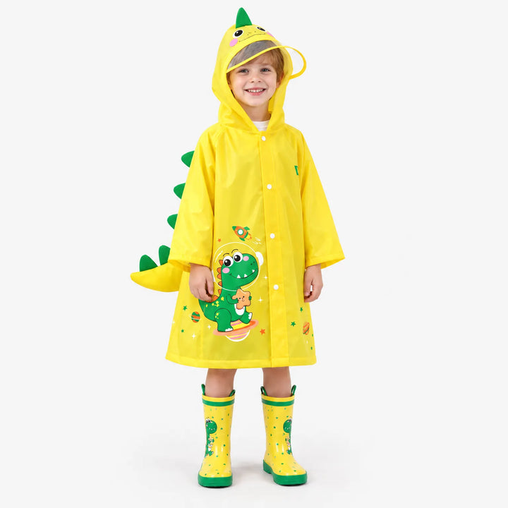Lachende jongen in gele regenjas met dinosaurusprint, groene rugstekels en staart, gedragen met bijpassende gele regenlaarzen. 2