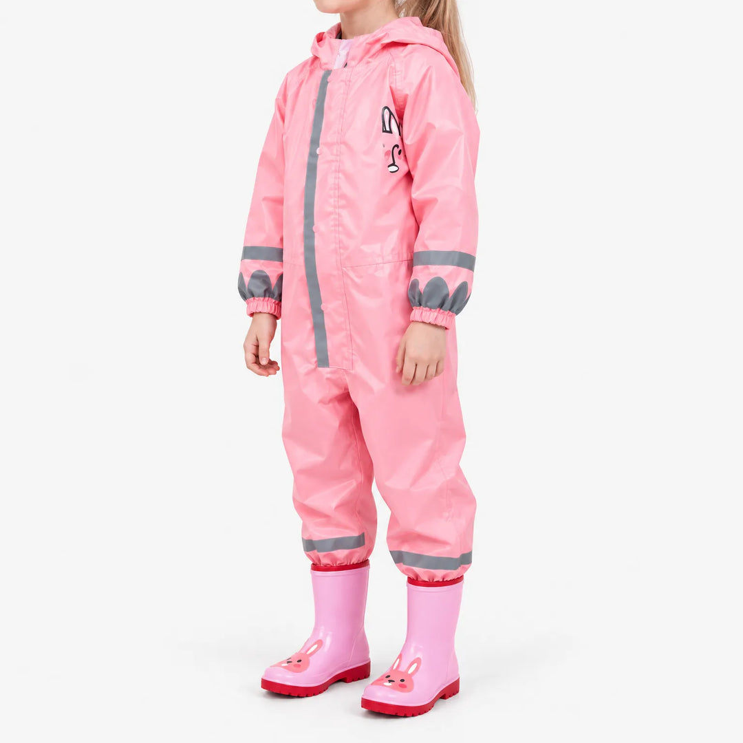 Roze regenpak met capuchon schuin van opzij gezien, met reflecterende strepen, een konijnenprint op de borst en roze laarzen met konijnengezicht. 5