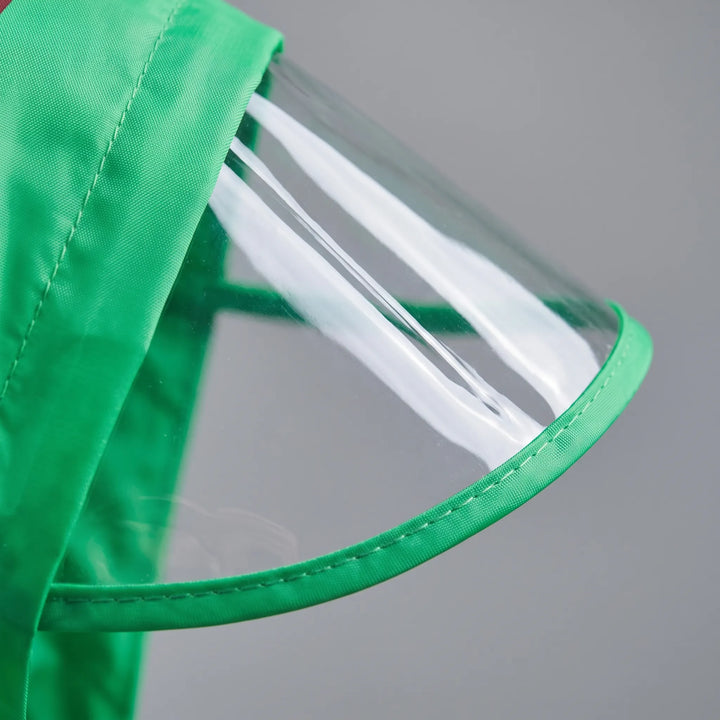 Close-up van de doorzichtige klep aan de capuchon van het groene regenpak, met een afwerkrand van groene stof. 6