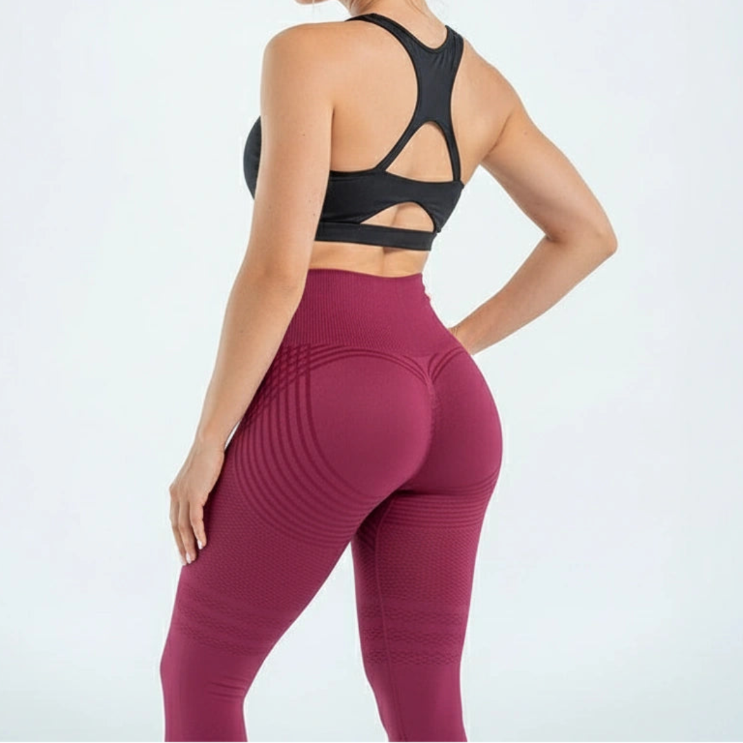 Achteraanzicht van een bordeauxrode legging met gebogen strepen over de billen, gedragen met zwarte sporttop met open rug. 6