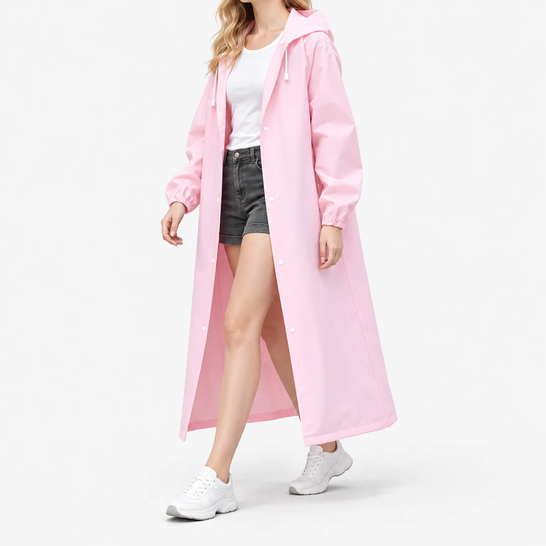 Model loopt in roze lange regenjas met capuchon en drukknopen, open gedragen over wit shirt en korte spijkerbroek, op witte achtergrond. 5