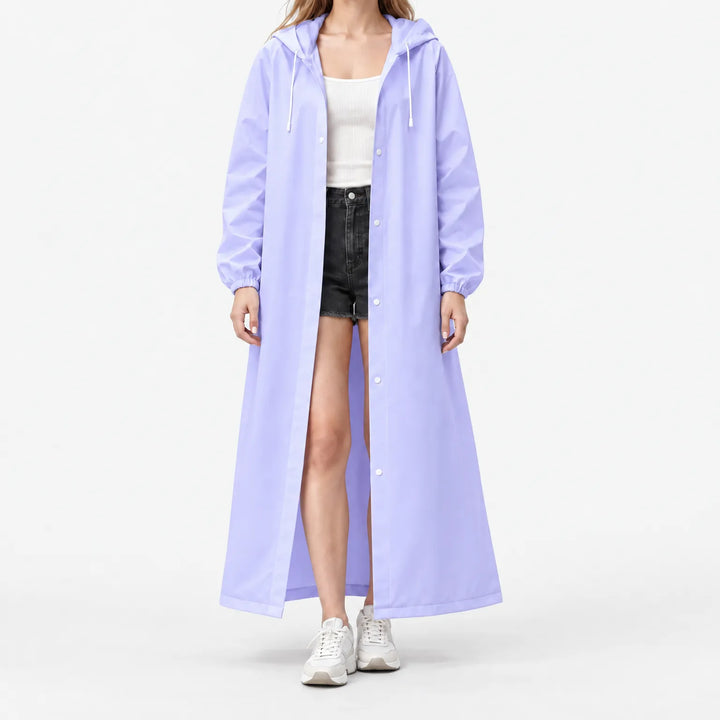 Model draagt de lange lila regenjas open met capuchon, drukknopen en elastische mouwuiteinden, over wit topje en zwarte korte broek. 9