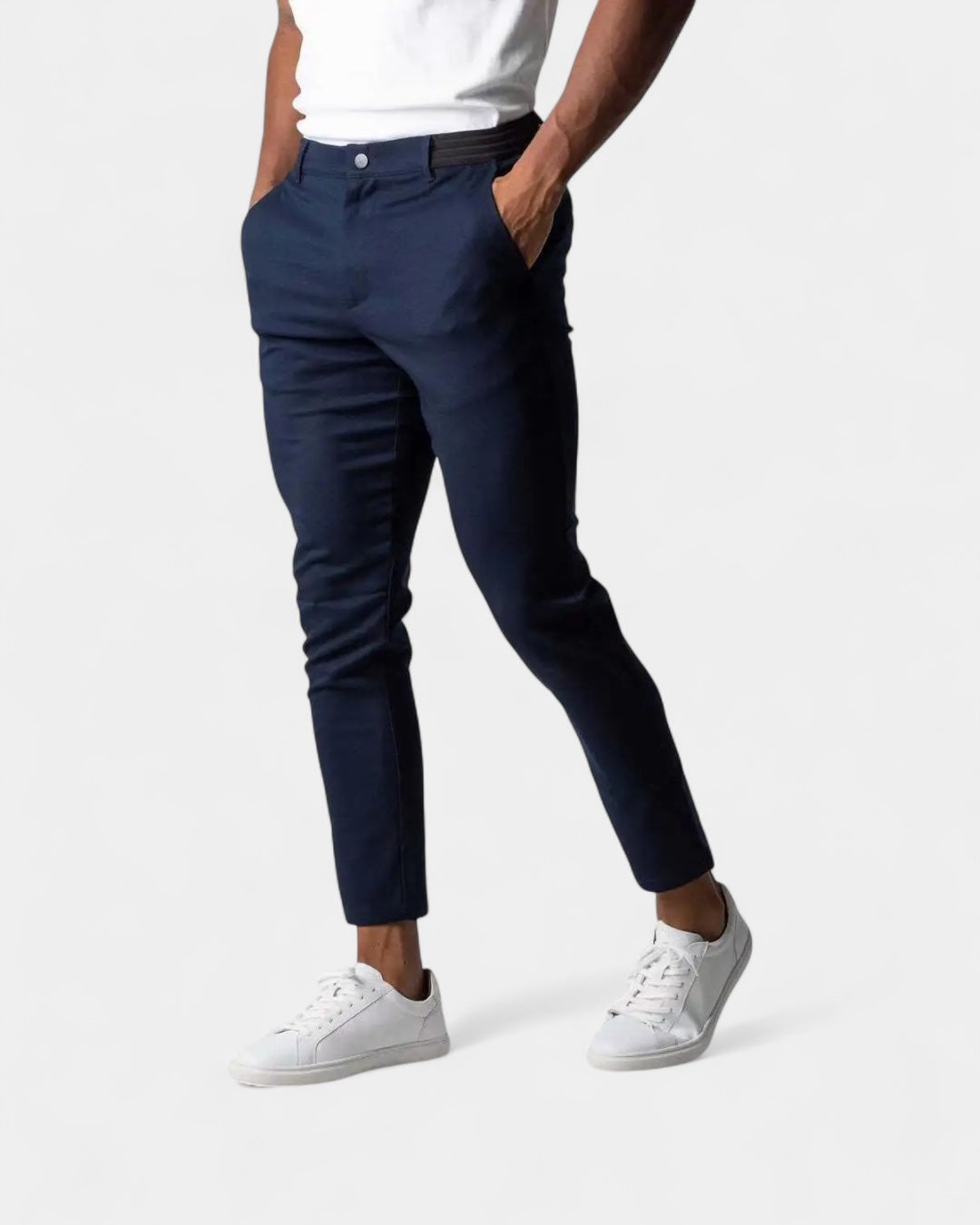 Model draagt de donkerblauwe broek met zwarte elastische tailleband aan de zijkant, gecombineerd met witte sneakers 2