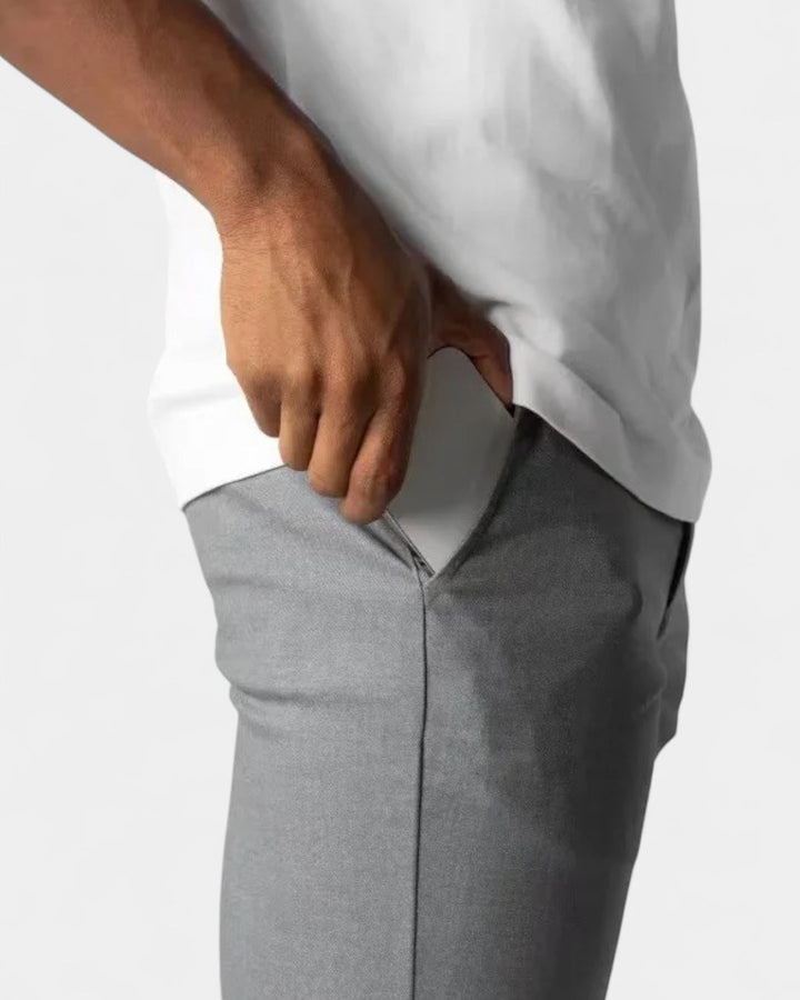 Close-up van de zijzak van de grijze broek, met een hand die de zak opent 6