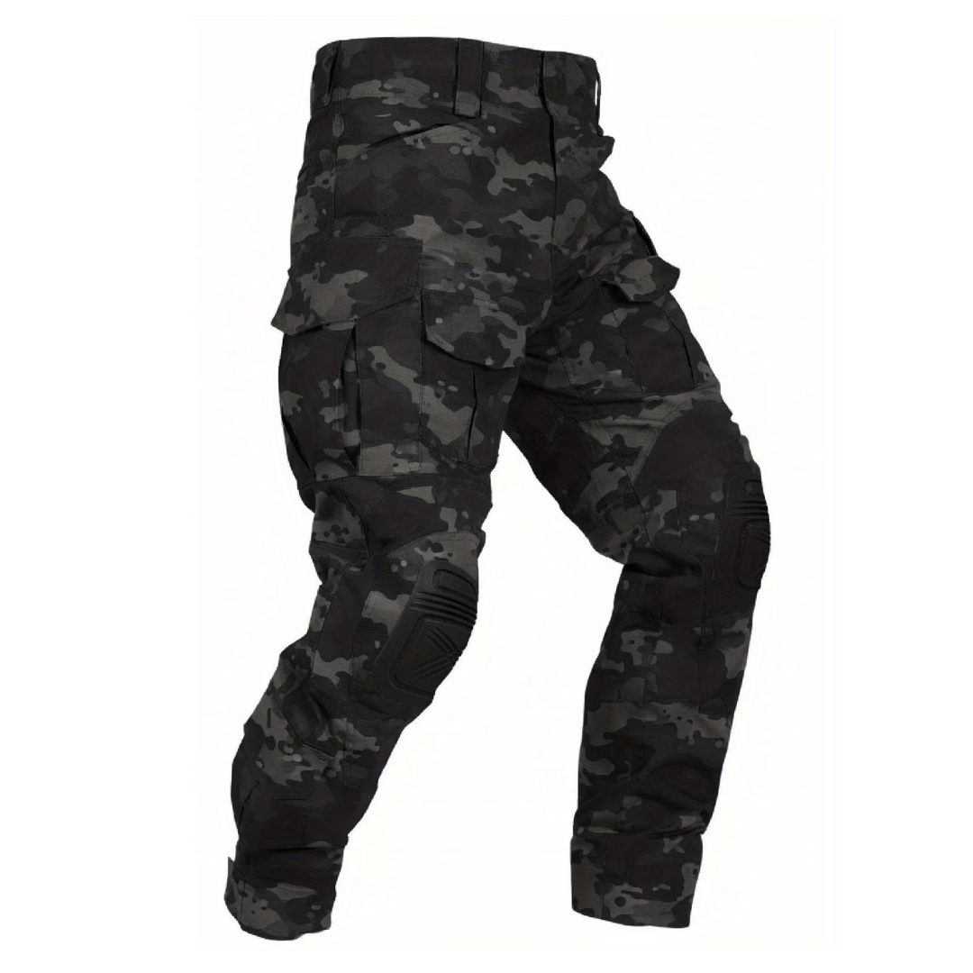 Cargobroek in zwart en donkergrijs camouflageprint met zwarte kniekappen, schuin van voren losgelegd op een witte achtergrond. 14