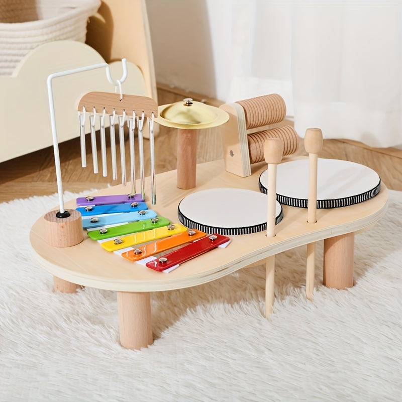 Muziektafel op een wit hoogpolig kleed, met houten stokjes in de gaten naast de trommels en de windgong links. 6