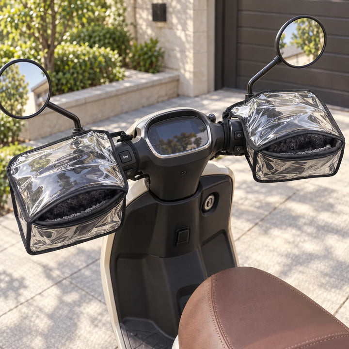 Doorzichtige stuurmoffen met zwarte rand en pluizige voering gemonteerd op het stuur van een witte scooter, gezien van boven buiten. 1