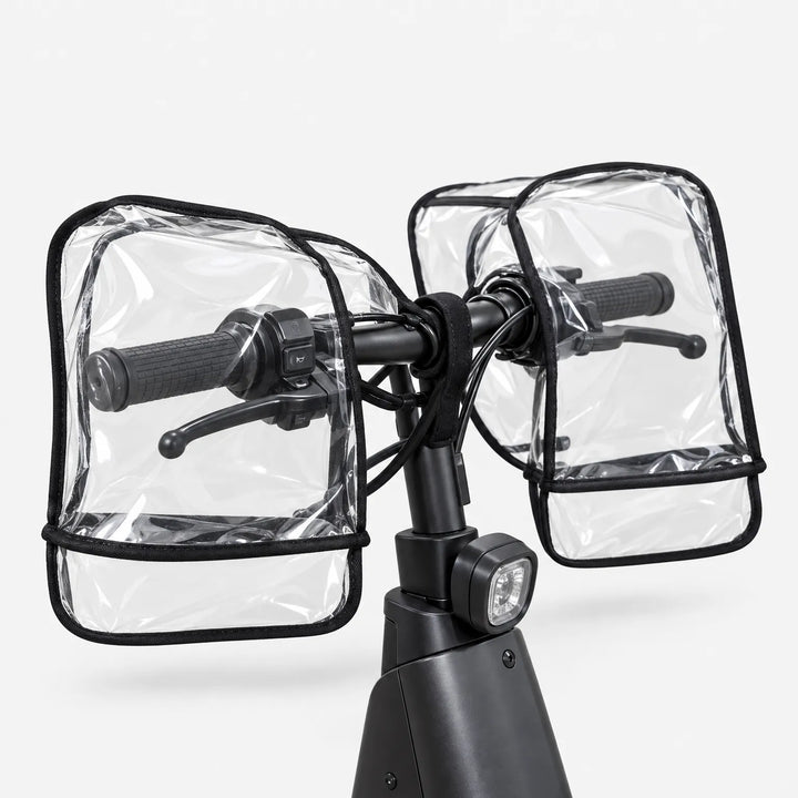 Doorzichtige stuurmoffen om beide stuurhandvatten, gezien vanaf de zijkant met de remhendels en handvatten zichtbaar door het plastic. 4