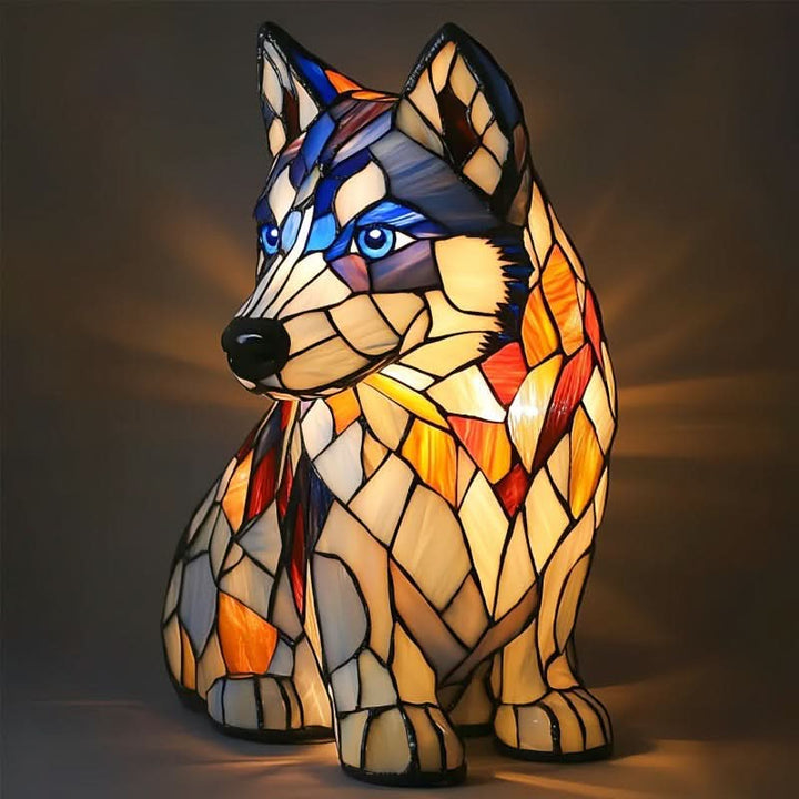Zittende husky als glasmozaïeklamp met blauwe ogen, crèmekleurige en oranje glasdelen en lichtstralen op de donkere achtergrond. 15