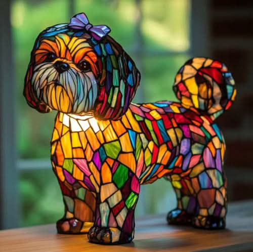 Verlichte lamp in de vorm van een kleine hond met paarse strik, gekleurde glasvlakken en krullende staart, op een houten vensterbank. 23