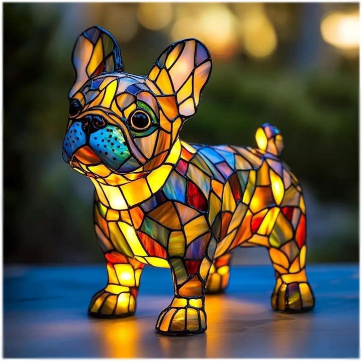 Franse bulldog als glasmozaïeklamp met rechte oren en blauwe snuit, warm verlicht op een tafel buiten in de schemering. 7