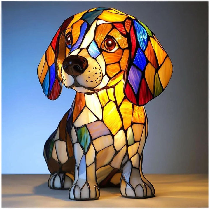 Zittende beagle-achtige hond als brandglaslamp, met kleurrijke glasstukjes in oranje, blauw en rood die warm oplichten tegen een blauwe achtergrond. 1