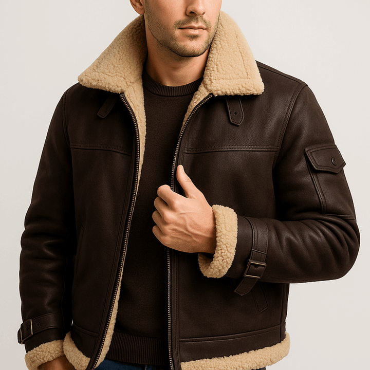 Model draagt de donkerbruine leren jas met beige teddykraag, schouderlipjes en mouwzak, open over een donkere trui. 8