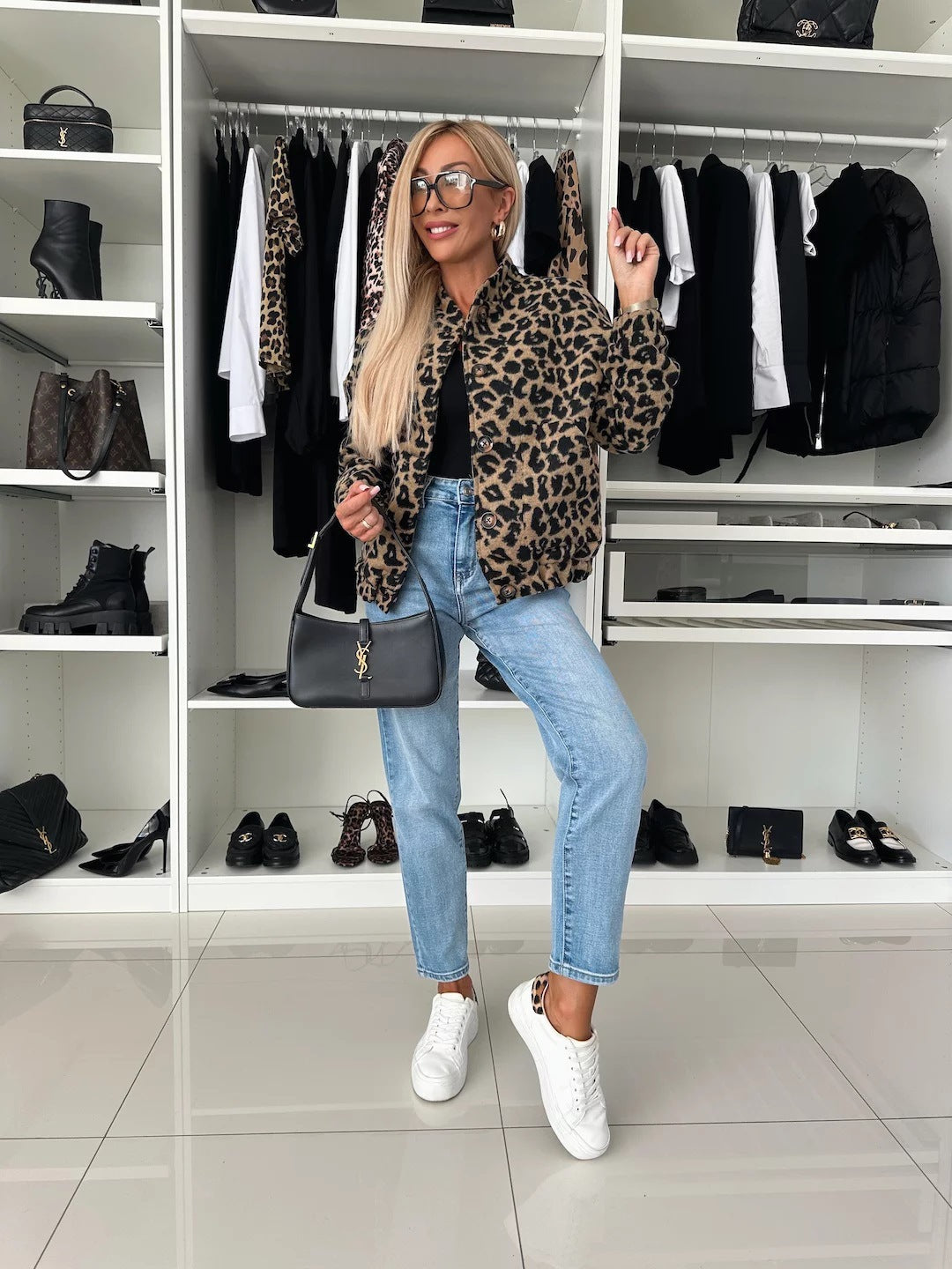 Volledige outfit met het luipaardprint overhemd, een zwarte top, spijkerbroek, witte sneakers en een zwarte schoudertas in een kledingkast. 5