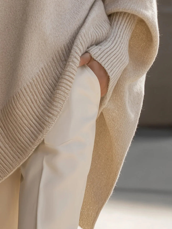 Close-up van de zijsplit en de geribde zoom, met een hand in de zak van een witte broek. 5