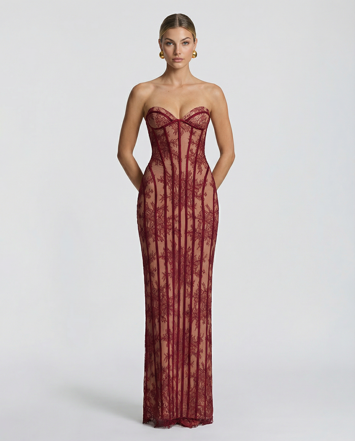 Vooraanzicht: model draagt de strapless maxi-jurk van bordeauxrode bloemenkant met korsetbanen, opgestoken haar en gouden oorbellen. 1