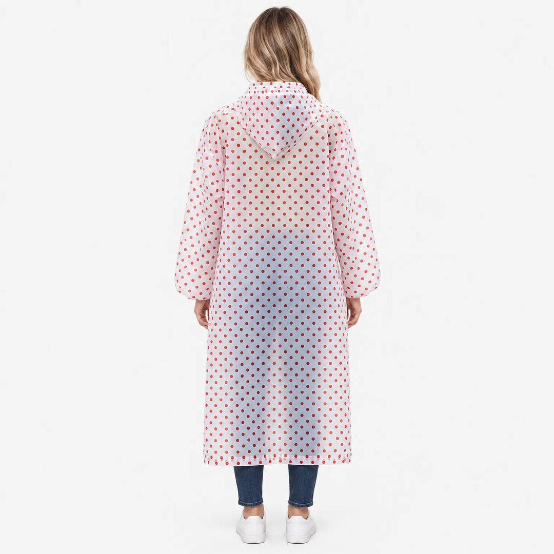 Achterkant van de doorzichtige regenjas met rode stippen, gedragen door een vrouw; de capuchon hangt op de rug, mouwen met elastische manchetten. 4