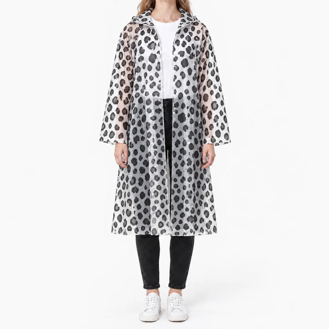 Vrouw draagt de doorzichtige regenjas met zwarte luipaardprint en capuchon, open gedragen over wit shirt en zwarte broek. 8
