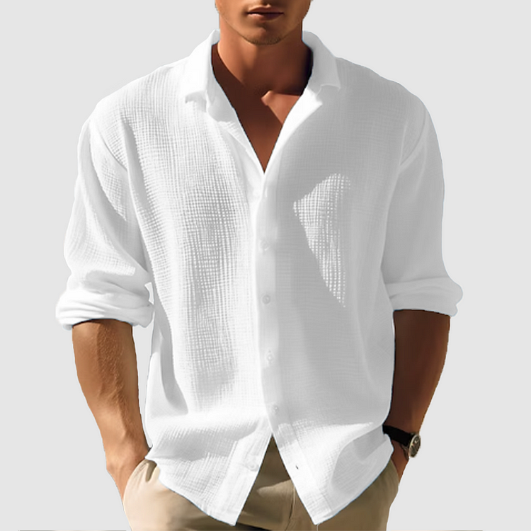 Model draagt het gestructureerde overhemd in wit, mouwen opgerold, gecombineerd met een beige broek en een horloge. 2