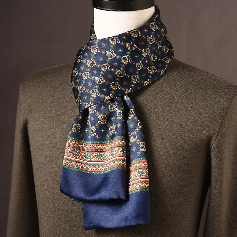 Marineblauwe zijden sjaal met gouden motieven, kleine ruitjes en kleurige paisleyrand, om een paspop met olijfgroene trui. 20