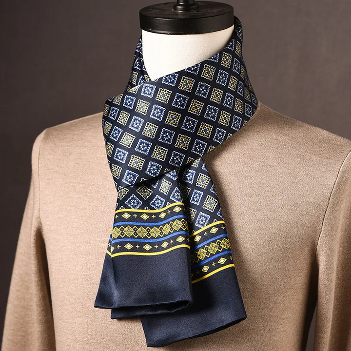 Donkerblauwe zijden sjaal met blauw-gele ruitjesmotief en gele rand met blauwe streep, gedrapeerd om een paspop met beige trui. 22