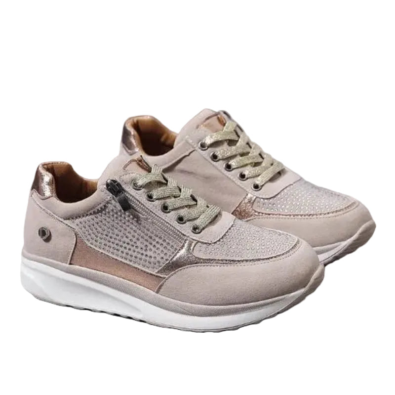 Paar beige damessneakers met glittersteentjes, ritssluiting en veters, vrijstaand op een witte achtergrond 1