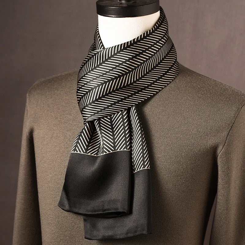 Zwart-beige zijden sjaal met visgraatstrepen en brede zwarte rand, gedragen op een paspop met olijfgroene trui. 4