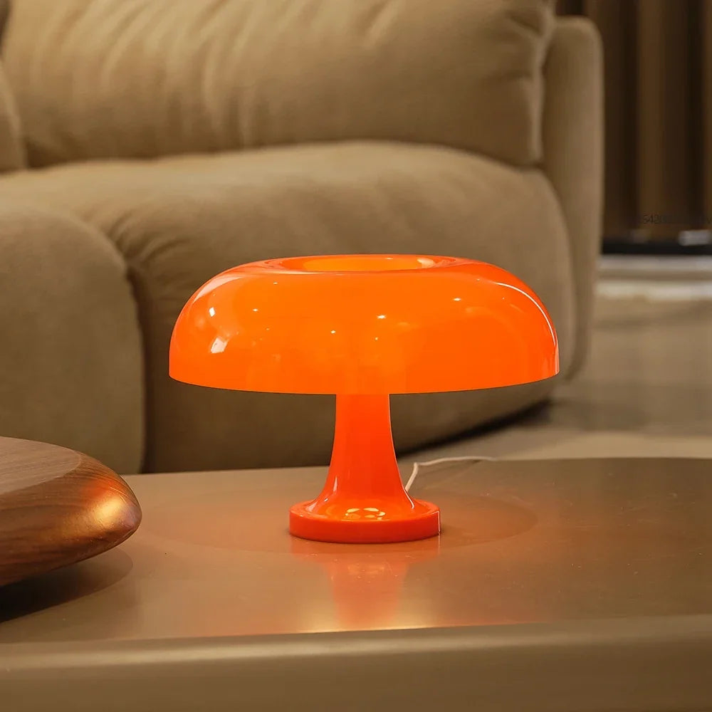 Oranje paddenstoellamp met zichtbaar wit snoer op een lage tafel voor een beige bank in een woonkamer. 5