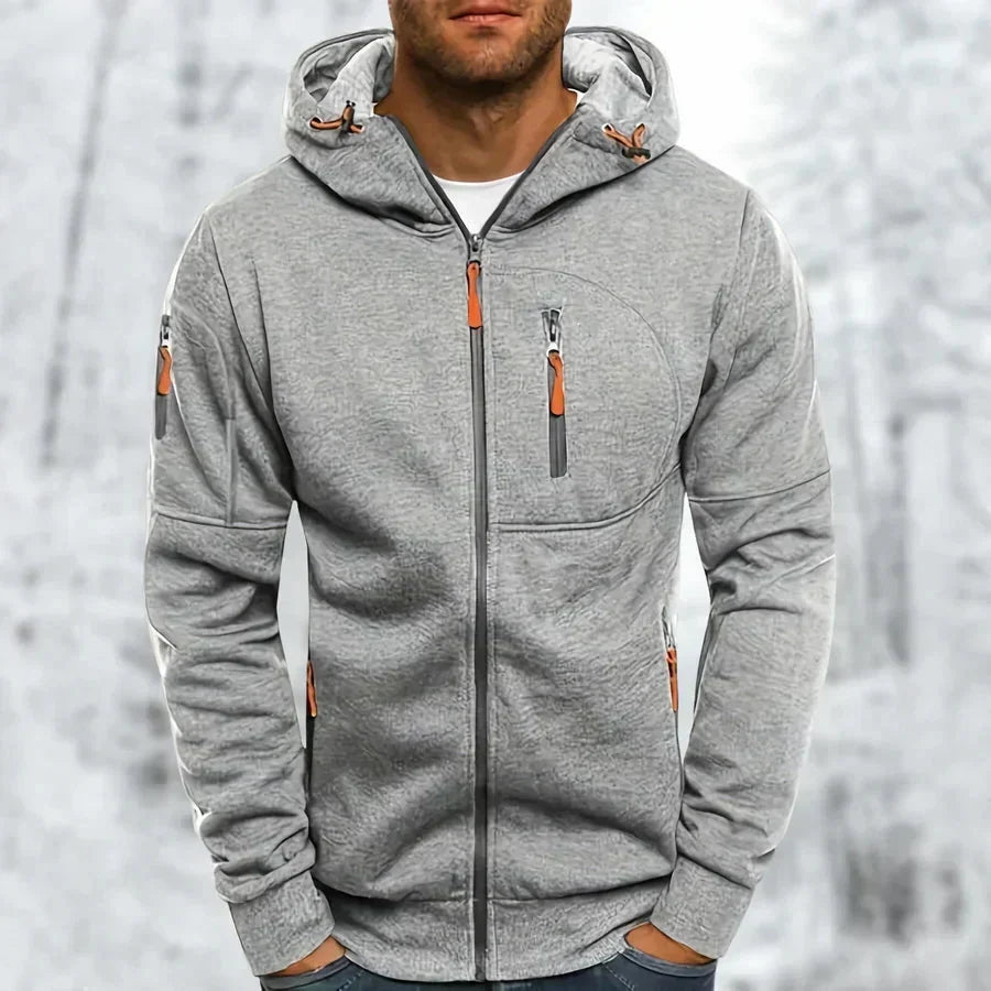 Lichtgrijze hoodie met gemêleerde jacquardstructuur en oranje ritstrekkers, voorkant gedragen door een model. 8