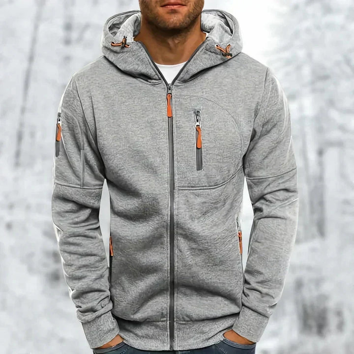 Lichtgrijze hoodie met gemêleerde jacquardstructuur en oranje ritstrekkers, voorkant gedragen door een model. 8