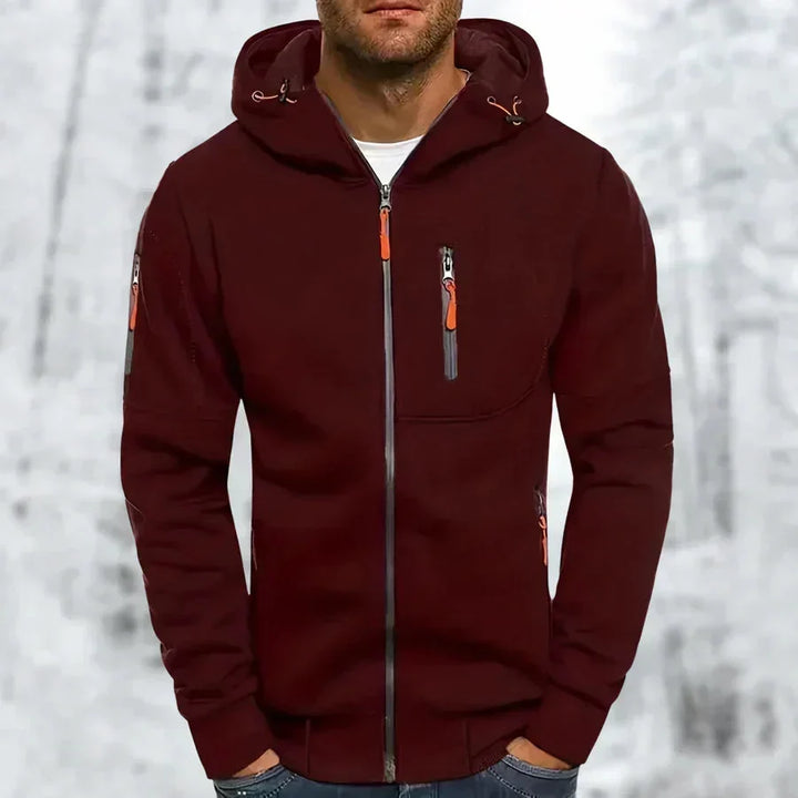 Model in bordeauxrode hoodie met oranje ritstrekkers, borstzak met rits en ritszak op de mouw, voorkant. 4