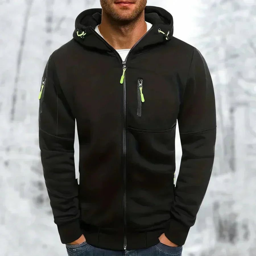 Zwarte hoodie met neongroene ritstrekkers, voorkant gedragen door een model, met borstzak en ritszak op de mouw. 7