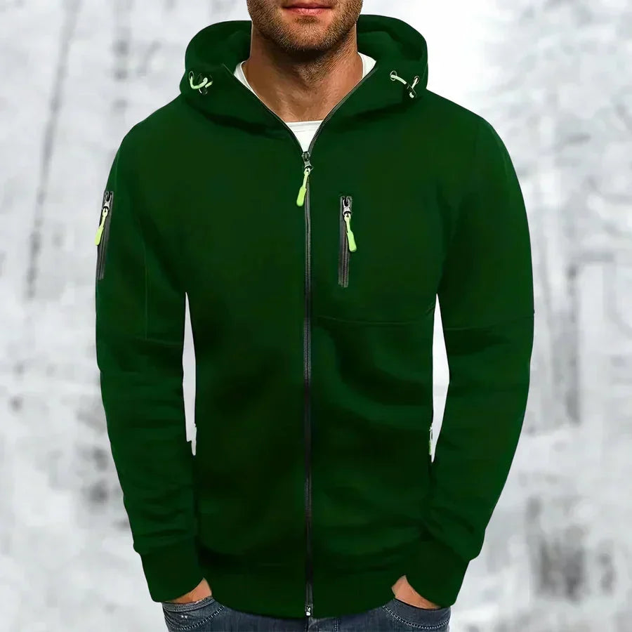 Donkergroene hoodie met neongroene ritstrekkers en trekkoordjes, voorkant gedragen door een model met handen in de zakken. 6