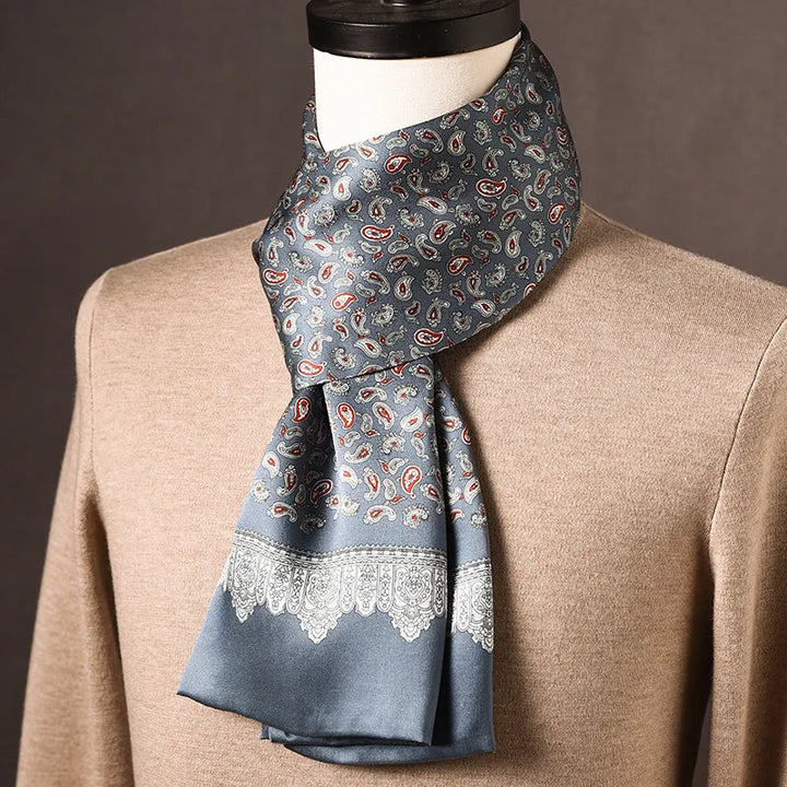 Grijsblauwe zijden sjaal met rode en witte paisleymotieven en kantachtige rand, op een paspop met beige trui. 18