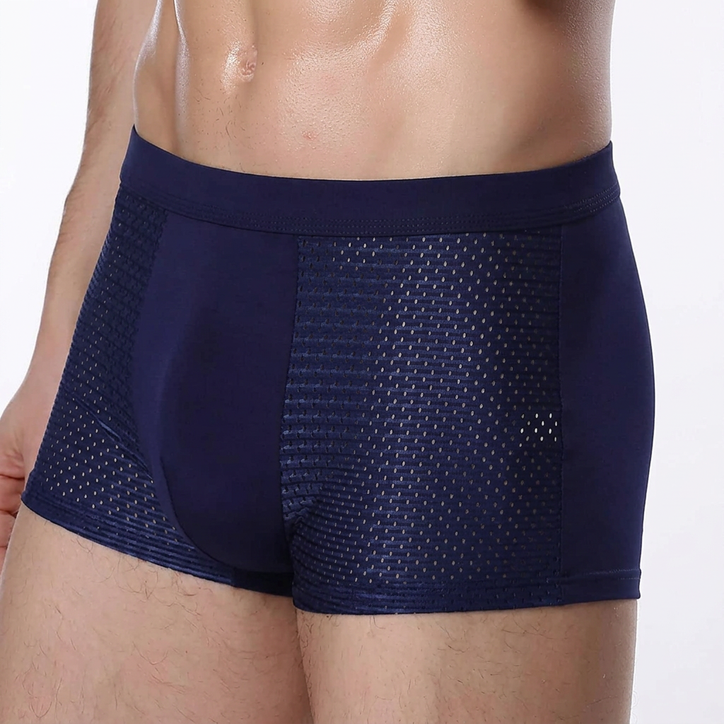 Close-up van een model in een marineblauwe boxershort, met gaatjesstof op de zijpanelen en een brede tailleband 5