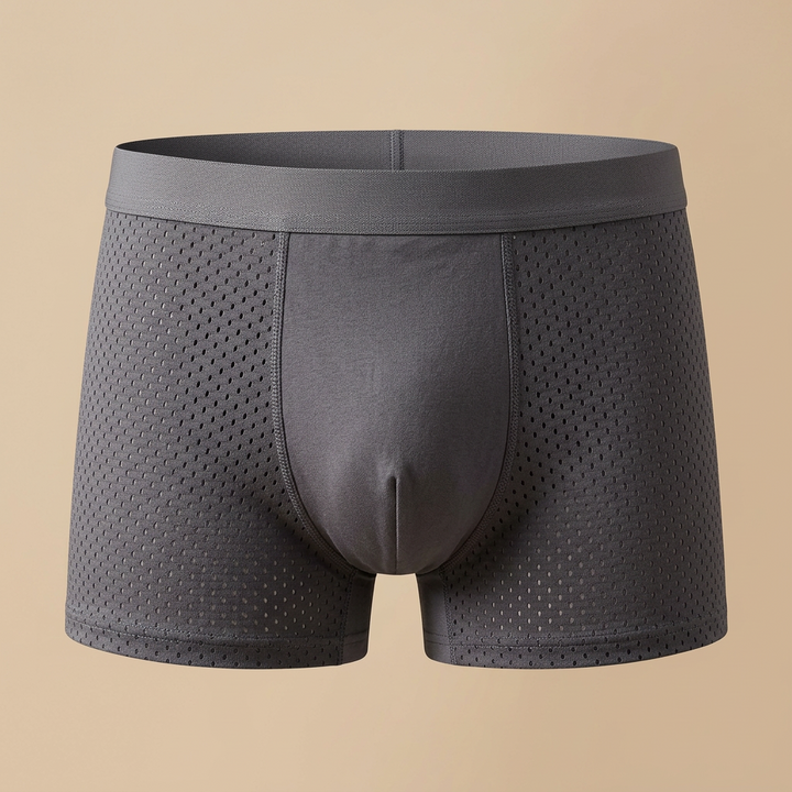 Grijze boxershort met geperforeerde zijpanelen en effen middenpaneel op een beige achtergrond 5
