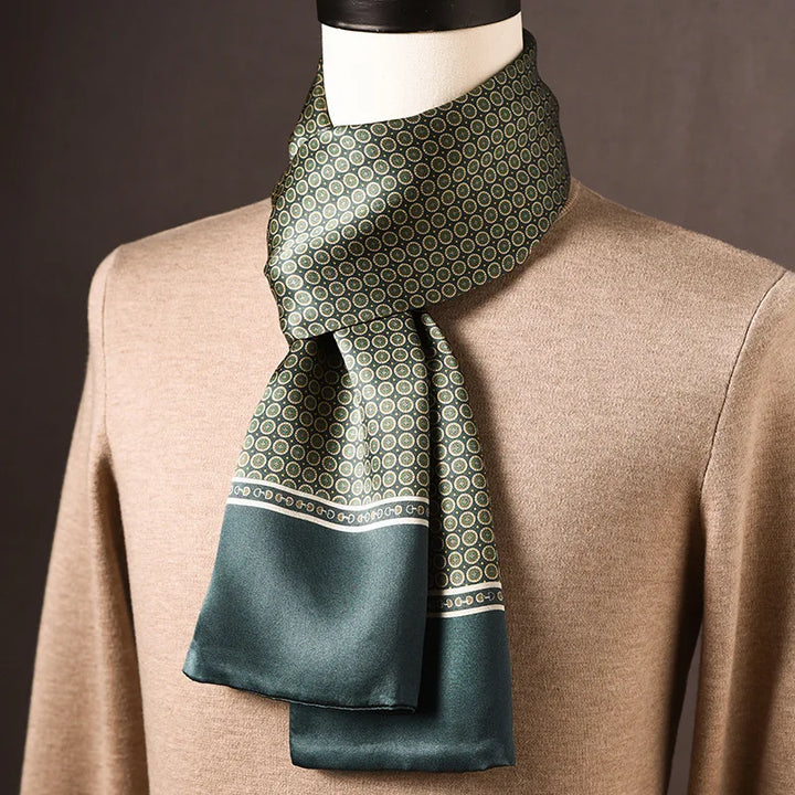 Groene zijden sjaal met klein rondmotief en effen groene rand met smalle sierstrook, op een paspop met beige trui. 8